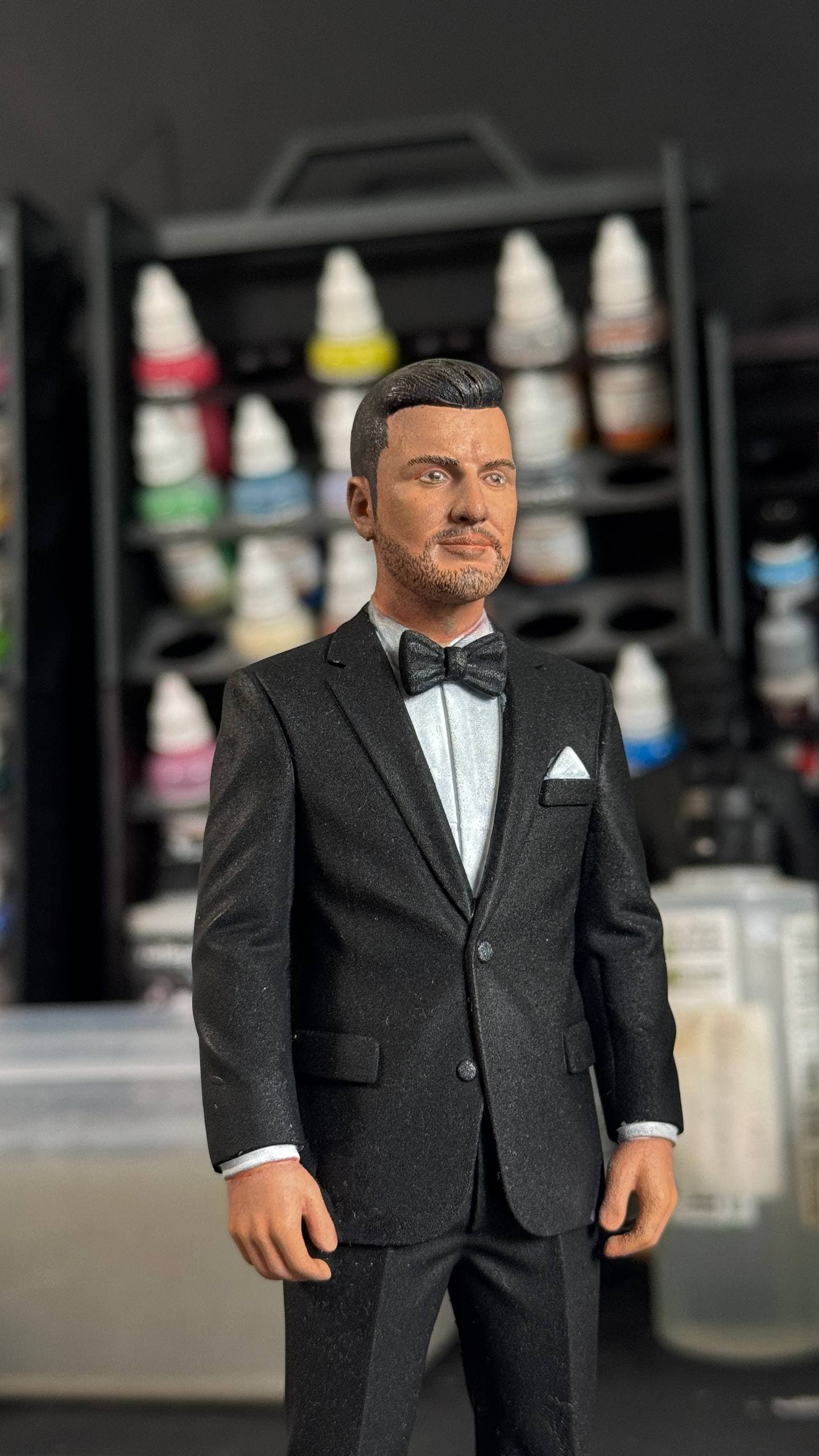 Close-up of the hand-painted groom in a black tuxedo and bow tie