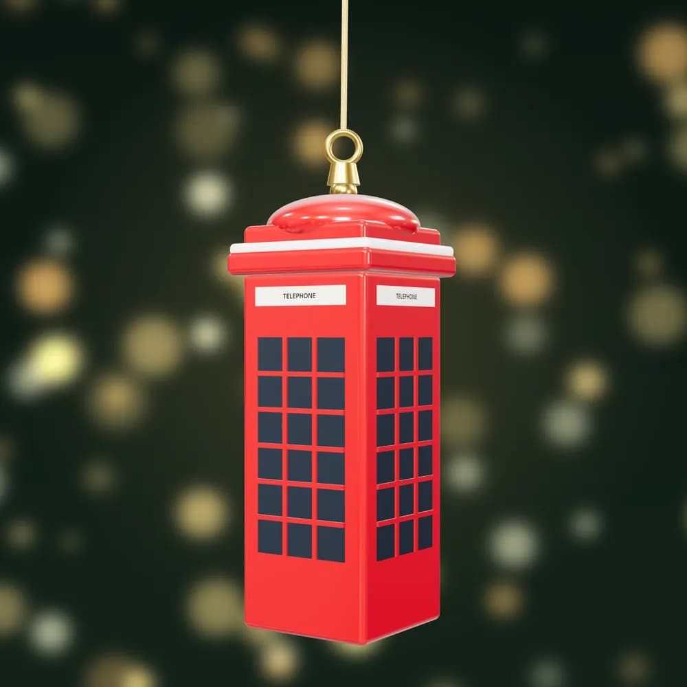 A glossy red London telephone box bauble with snow on its roof