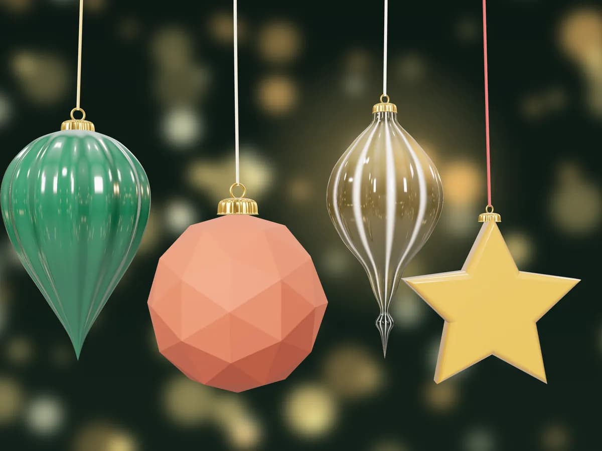 A green fluted teardrop, a faceted terracotta bauble, a glass-like finial and a gold star, hanging side by side