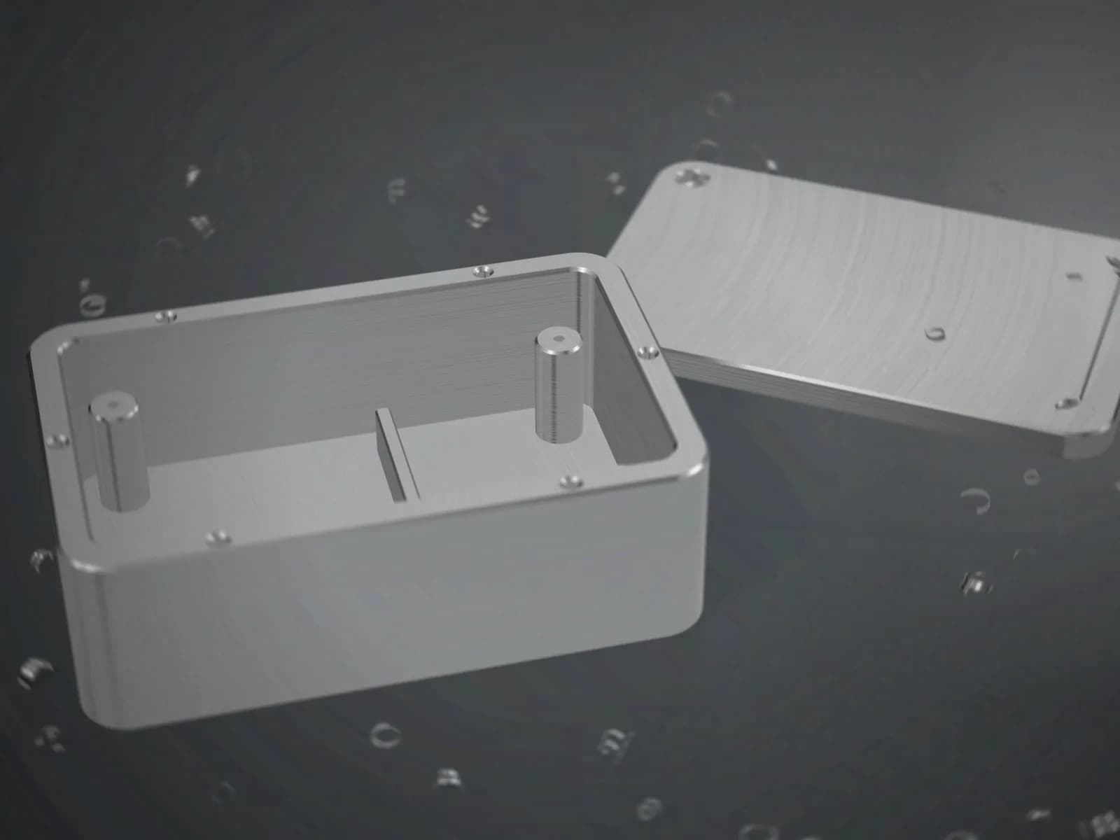 A machined aluminium enclosure with a deep pocket, mounting bosses and threaded holes, beside its lid
