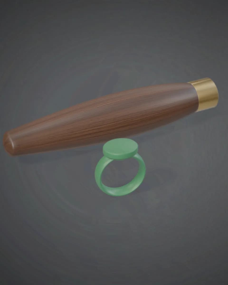 A turned walnut handle with a brass ferrule, beside a green jewellery wax ring