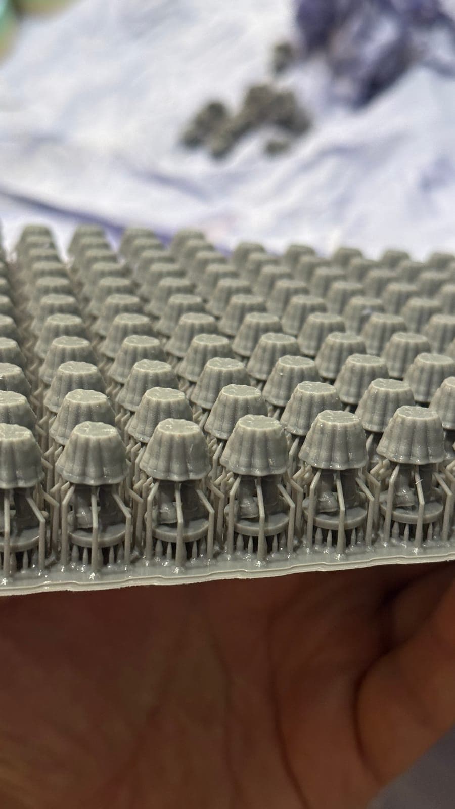 Rows of identical small resin parts on a build plate, printed as one batch