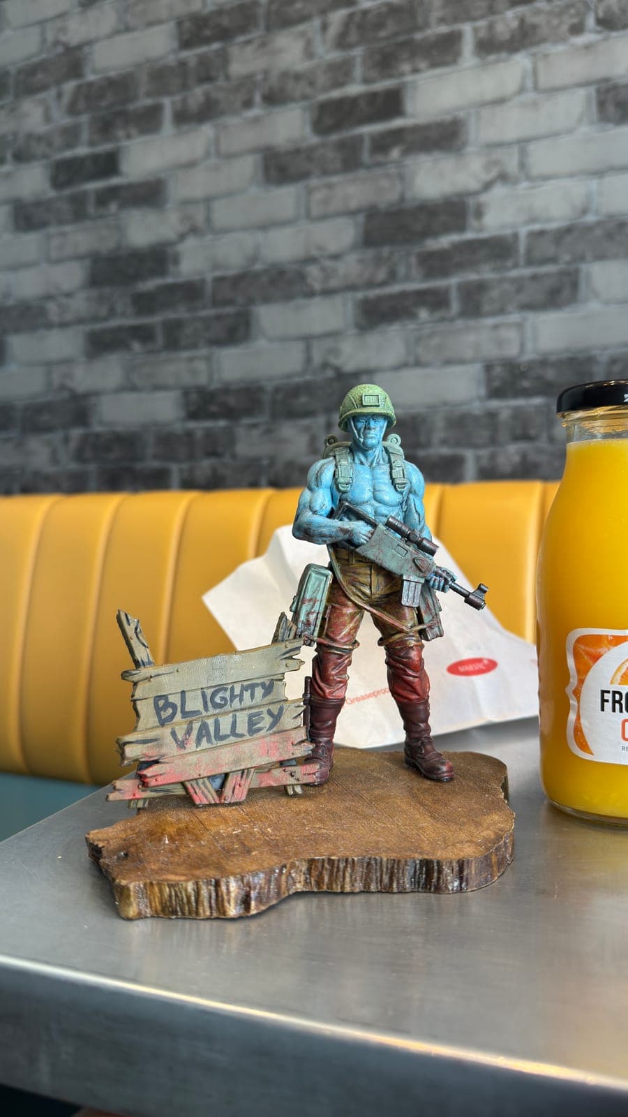A hand-painted soldier figure on a wooden base with a painted sign
