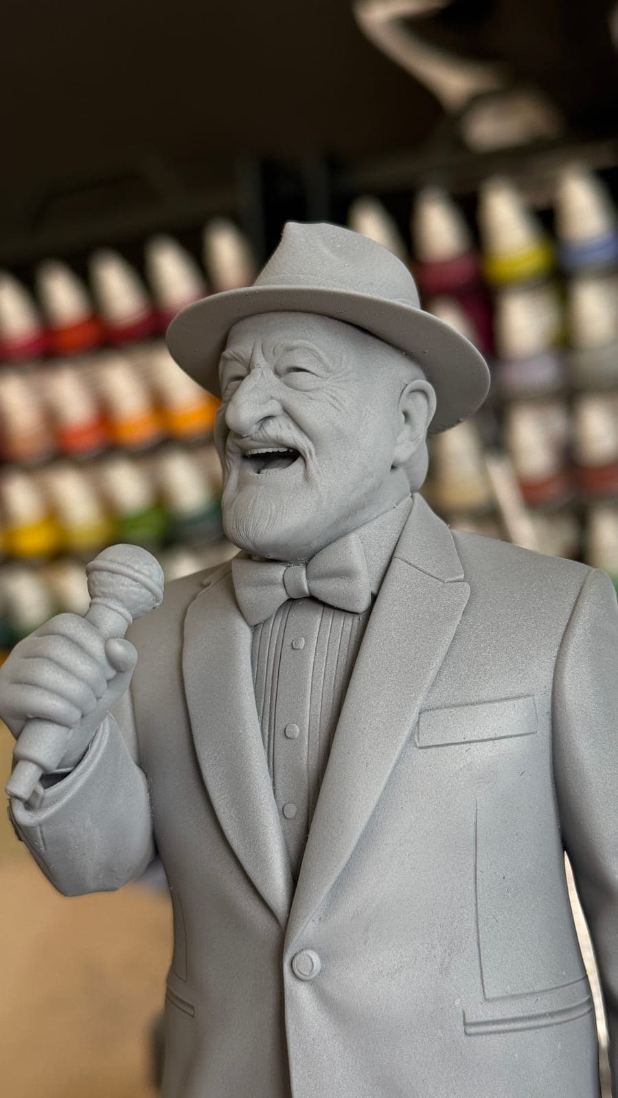 Close-up of the unpainted singer bust in front of the paint rack