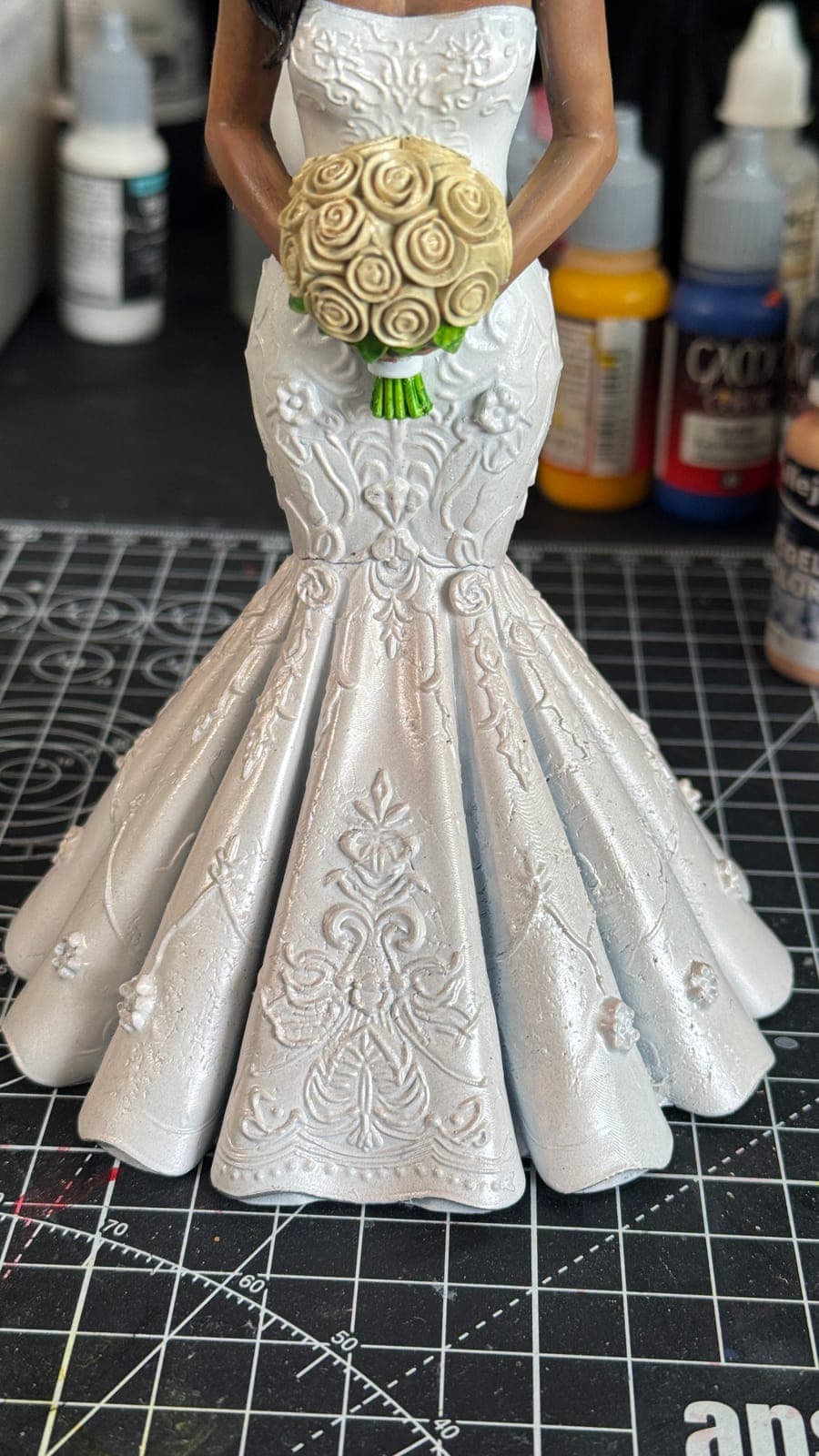 The lace detail of a resin-printed wedding dress with a bouquet