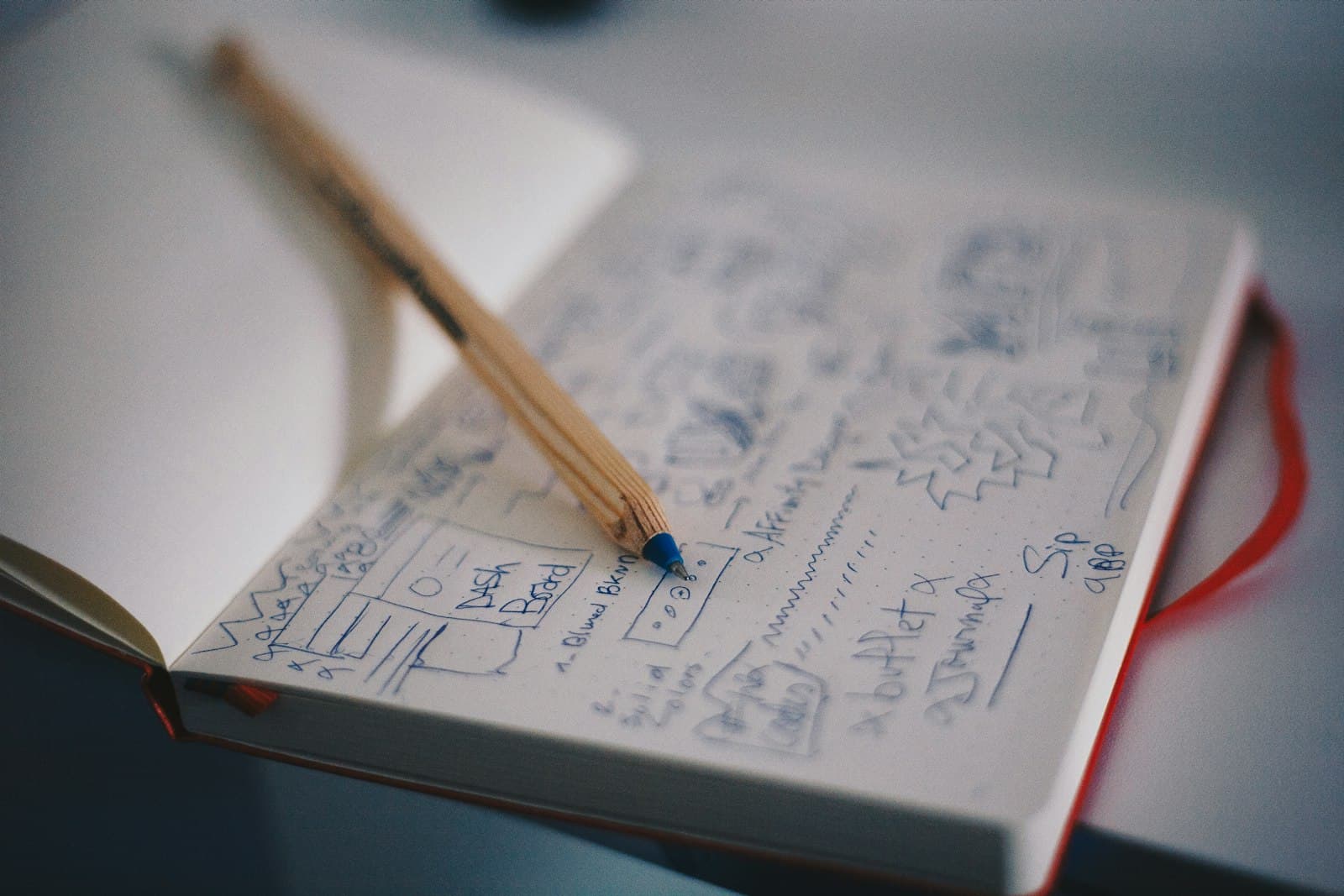 A pen resting on a notebook of sketches