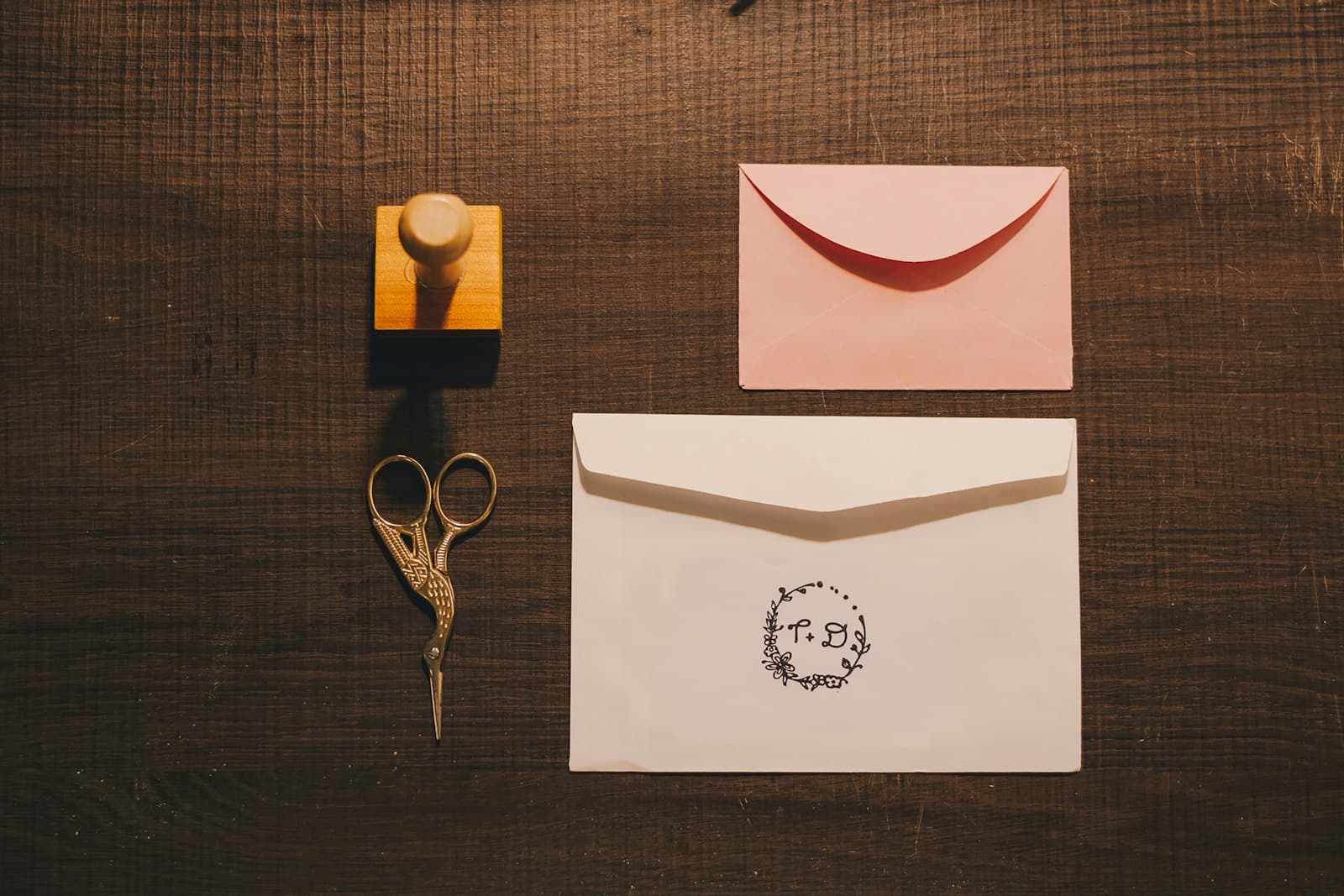 A stamp, scissors and envelopes marked with a stamped design
