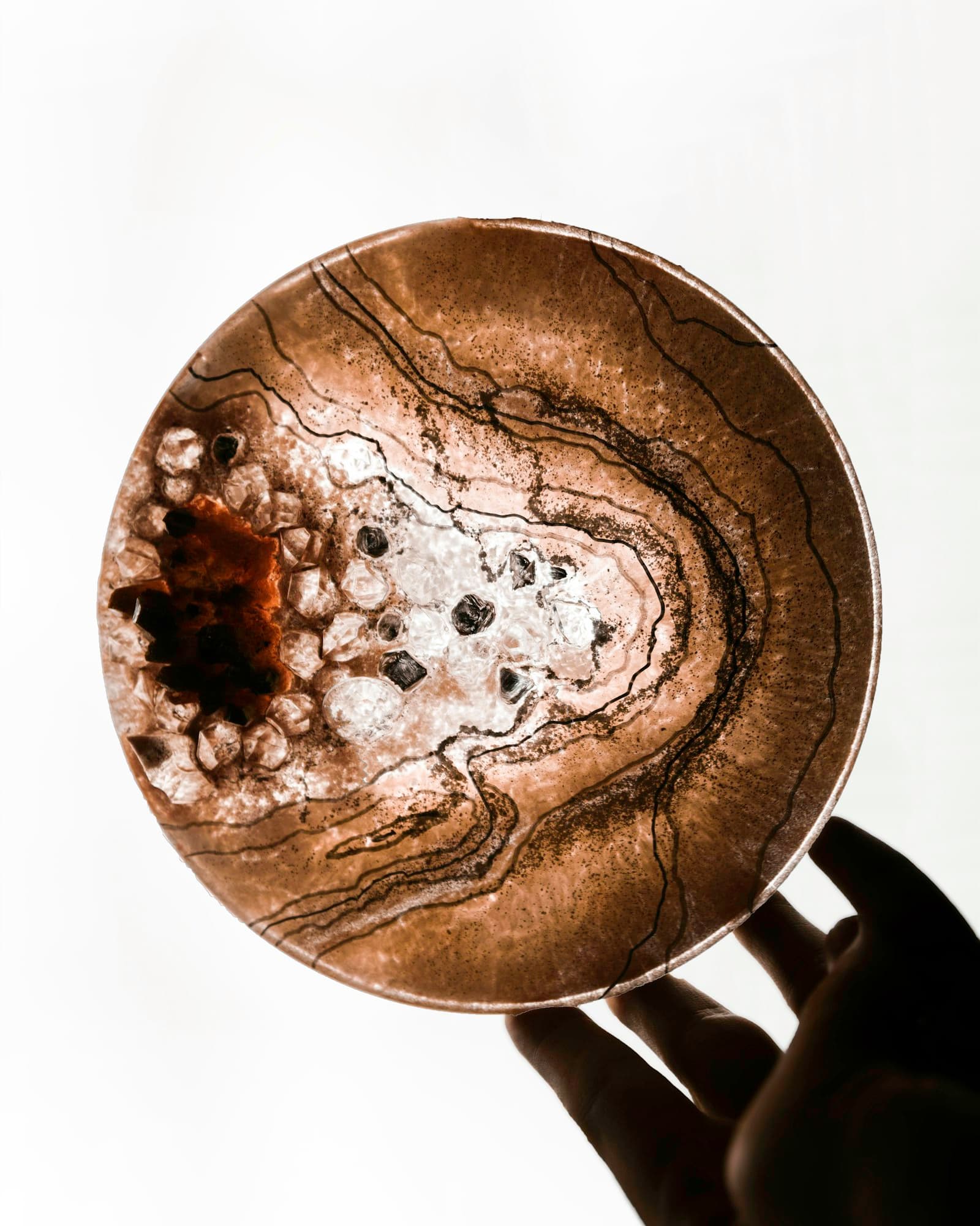 A pigmented resin disc held up to the light