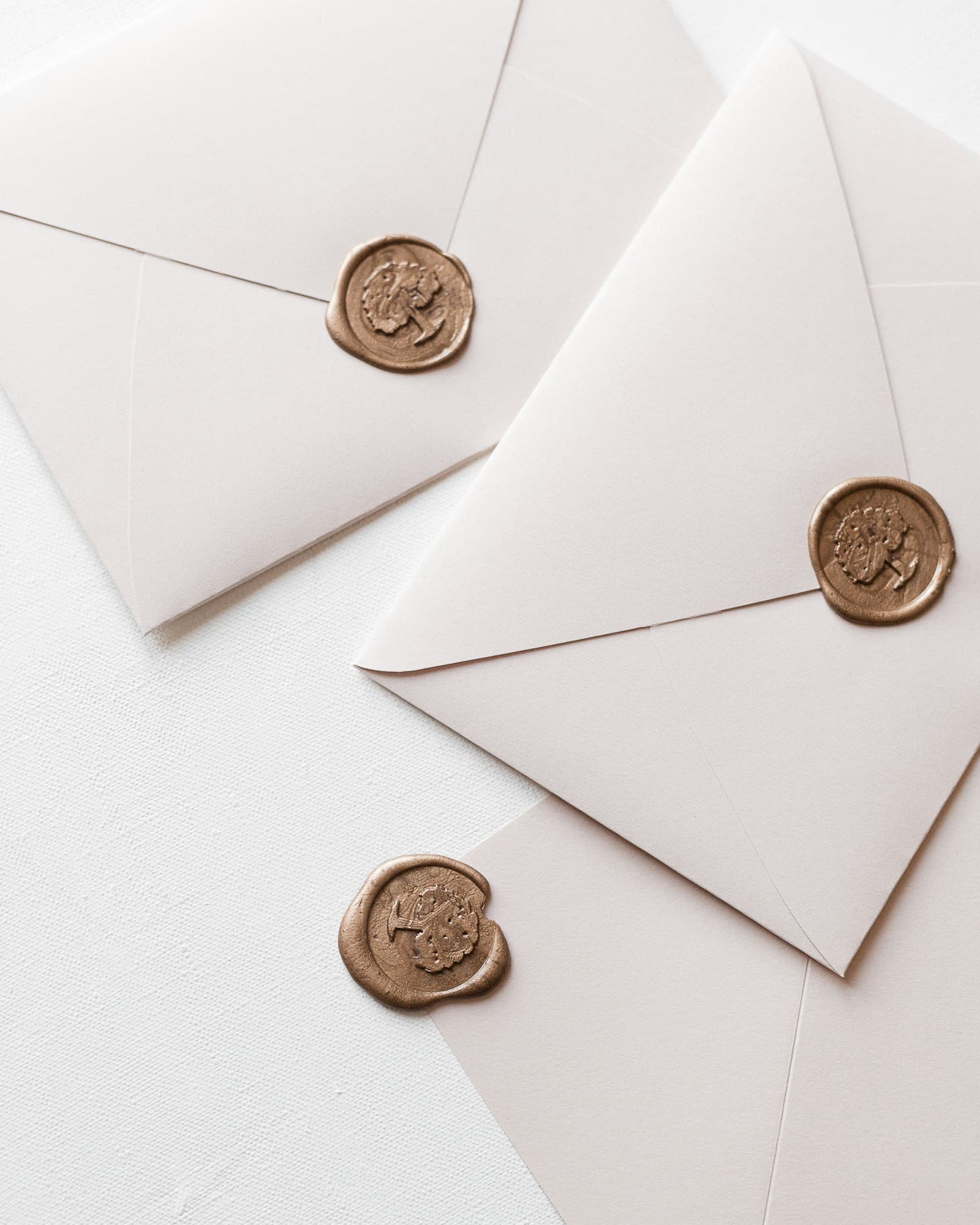 Gold wax seals on cream envelopes