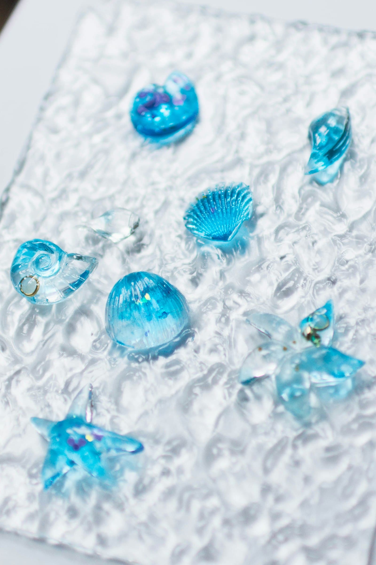 Clear blue shell-shaped pieces on a textured surface