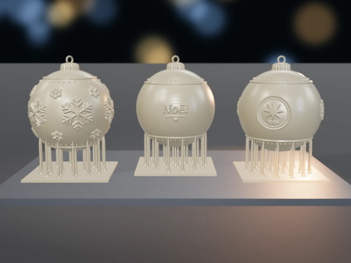 Three freshly printed baubles in clear UV resin, still on their supports on the printer's build plate
