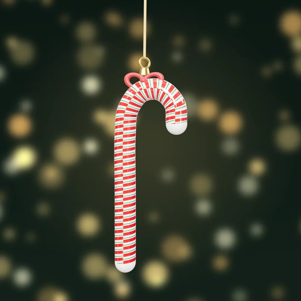 A glossy red, white and green striped candy cane bauble tied with a red velvet bow