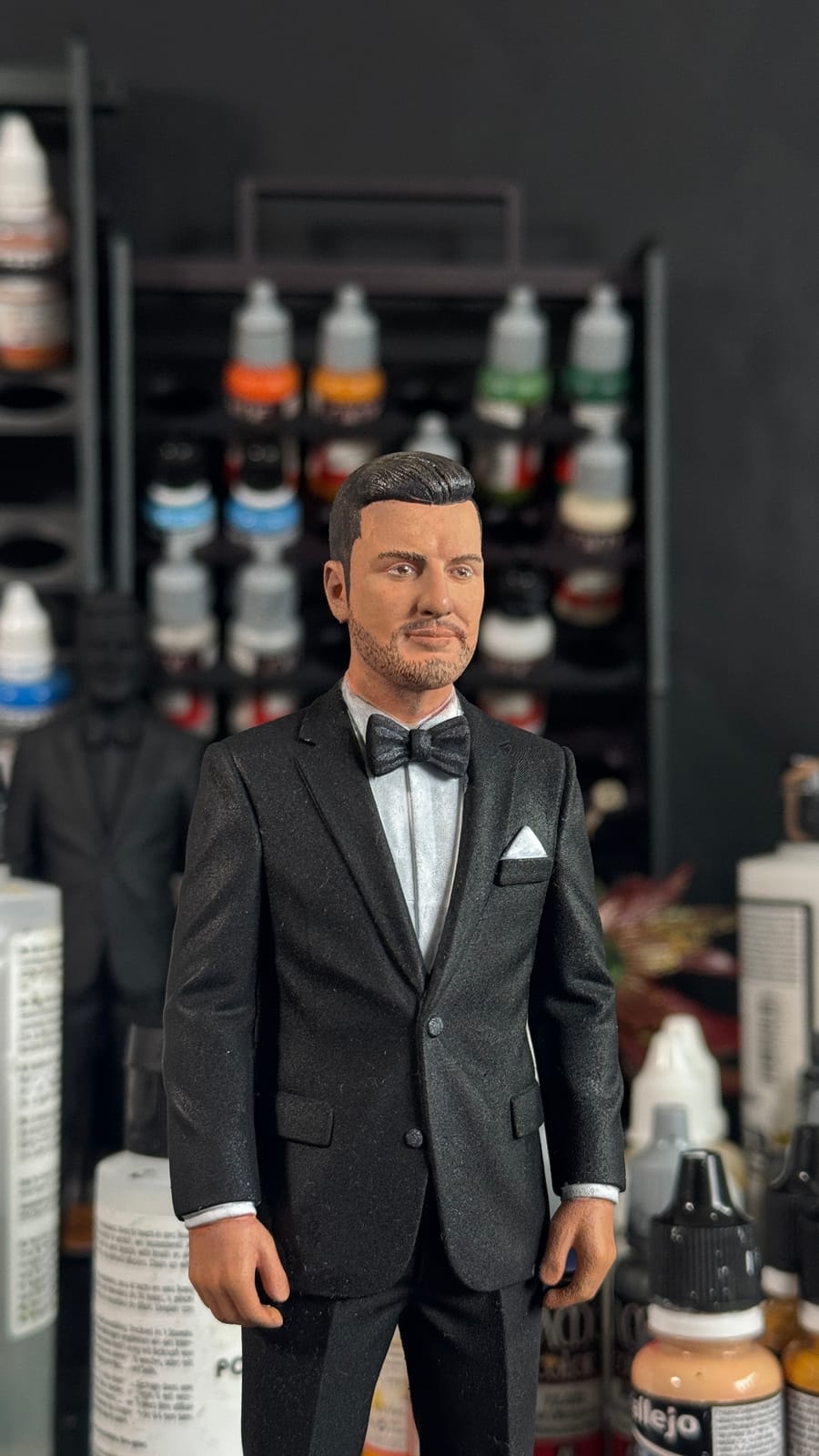 A hand-painted groom figurine in a black tuxedo