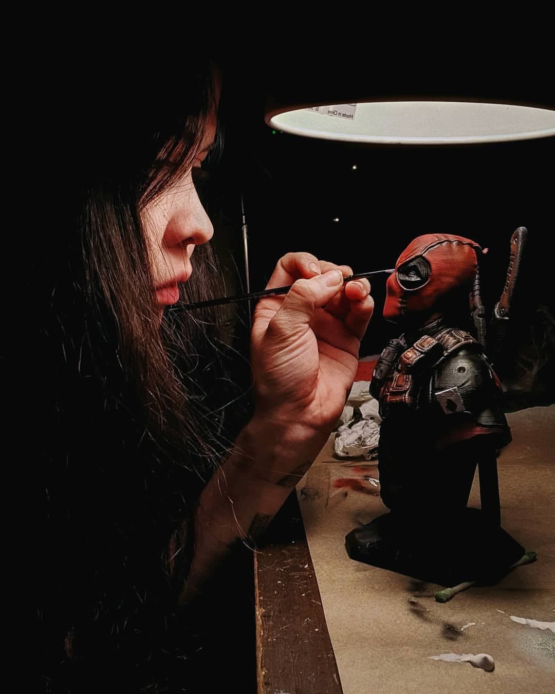 Hand-painting the detail on a Deadpool bust in the studio