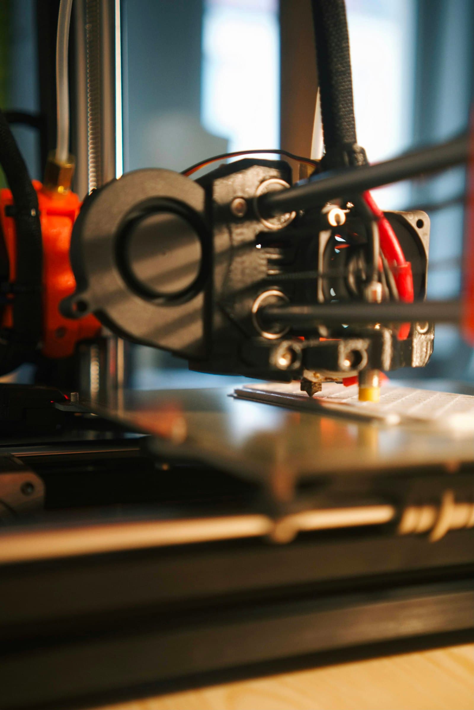 Close-up of an FDM extruder above the print bed