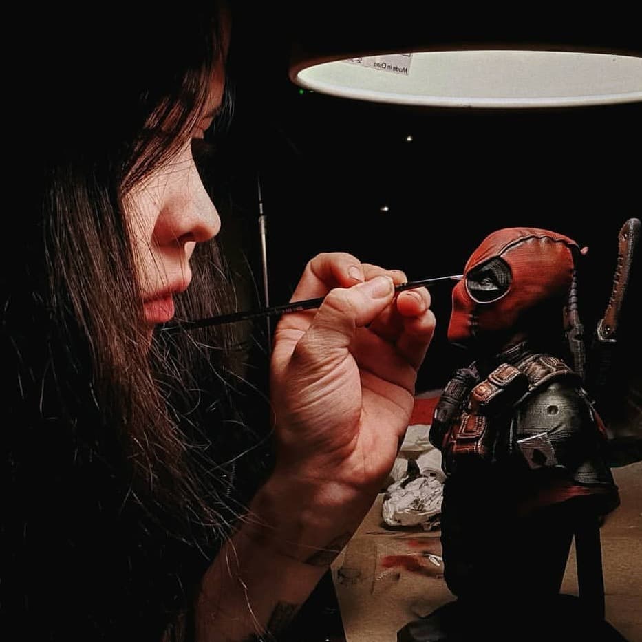 Hand-painting the detail on a Deadpool bust in the studio