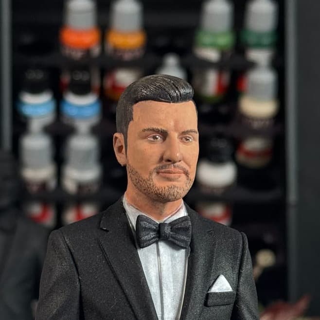 A hand-painted groom figurine in a black tuxedo